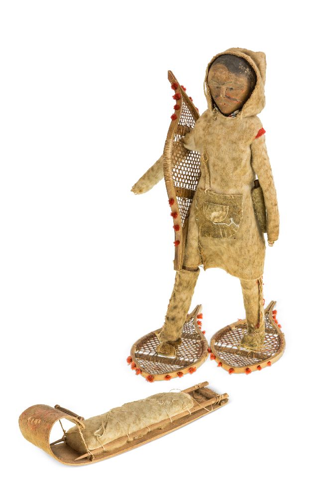 An Inuit carved wood figure, early 20th century, with carved and painted wooden face and wooden