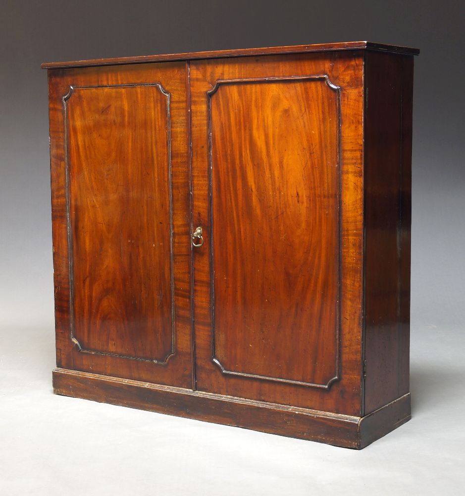 A Victorian mahogany side cabinet, circa 1860, with two paneled doors enclosing two shelves,