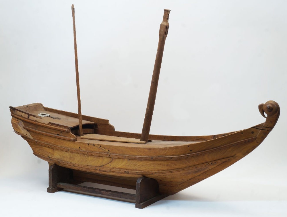 A large carved wood model of a Chinese Dhow, 20th century, having twin masts, at fault and missing