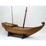 A large carved wood model of a Chinese Dhow, 20th century, having twin masts, at fault and missing
