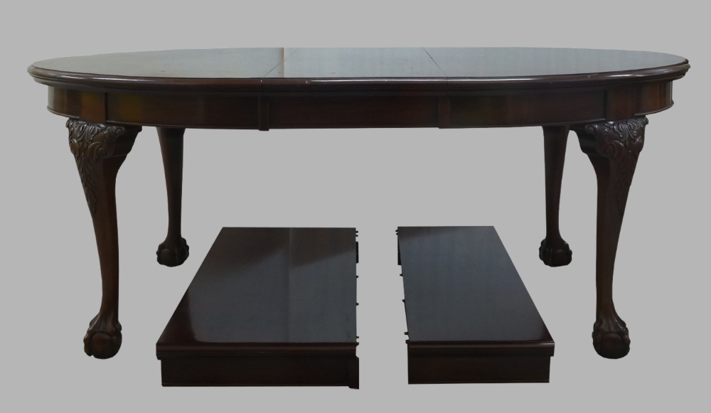 A George III style mahogany wind out dining table, 20th century, raised on carved legs with ball and