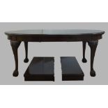 A George III style mahogany wind out dining table, 20th century, raised on carved legs with ball and