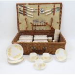 A Coracle wicker picnic hamper, 20th century, containing six Linga Longa Ware cups, four