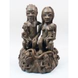 A modern terracotta figural group, Nigeria, depicting a family scene with a father and mother seated