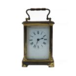 A French brass carriage timepiece, the corniche case with swing handle and bevelled glass panels,