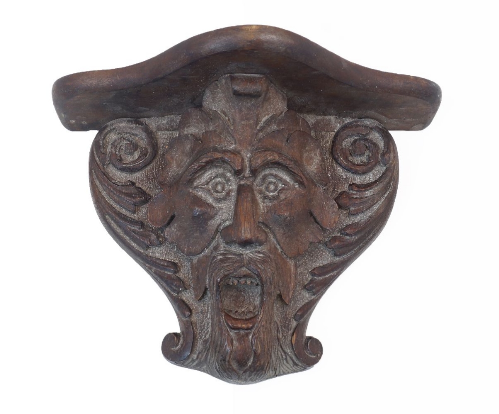 A carved oak wall bracket, late 19th / early 20th century, the support carved in the form of a Green