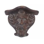 A carved oak wall bracket, late 19th / early 20th century, the support carved in the form of a Green