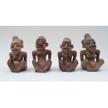 A group of four seated terracotta figures, Nigeria, 20th century, depicting two women with elaborate