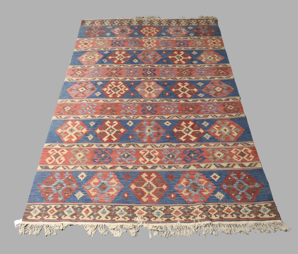 A Persian kilim carpet, late 20th century, geometric designs on a blue and red ground, 276cm x 188cm