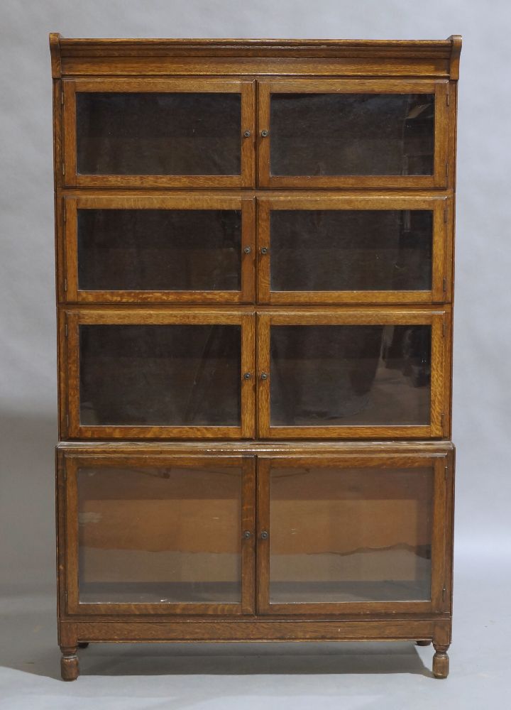 Minty of Oxford, an oak four section bookcase, early 20th century, with glazed doors, raised on