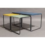 A set of three contemporary nesting tables, each with rounded rectangular tops in blue, yellow and