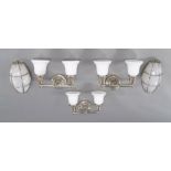 A set of three contemporary chromed twin branch metal wall lights, with white glass shades and