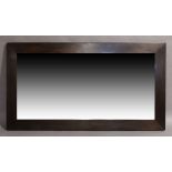 A large contemporary wenge mirror, thick mahogany veneered frame set with bevelled glass plate,