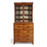 A George III mahogany secretaire bookcase, c.1800, the moulded cushioned cornice above two glazed...