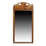 A George II walnut fret cut mirror, c.1740, the moulded rectangular frame with later bevelled pla...