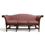 A George III and later mahogany camel back sofa, c.1800, reeded out scrolling armrests, raised on...