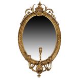 A Victorian gilt wood and gesso girandole, c.1860, the moulded beaded oval frame with carved shel...