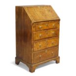 A George II walnut bureau, c.1740, of small proportions, the hinged fall front enclosing pigeon h...