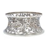A silver dish ring, apparently unmarked, pierced and engraved with exotic birds, a dolphin and a ...