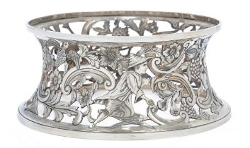A silver dish ring, apparently unmarked, pierced and engraved with exotic birds, a dolphin and a ...