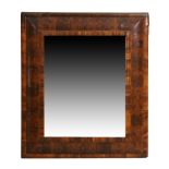 A William & Mary oyster veneered walnut cushion framed mirror, c.1700, the moulded framed with la...