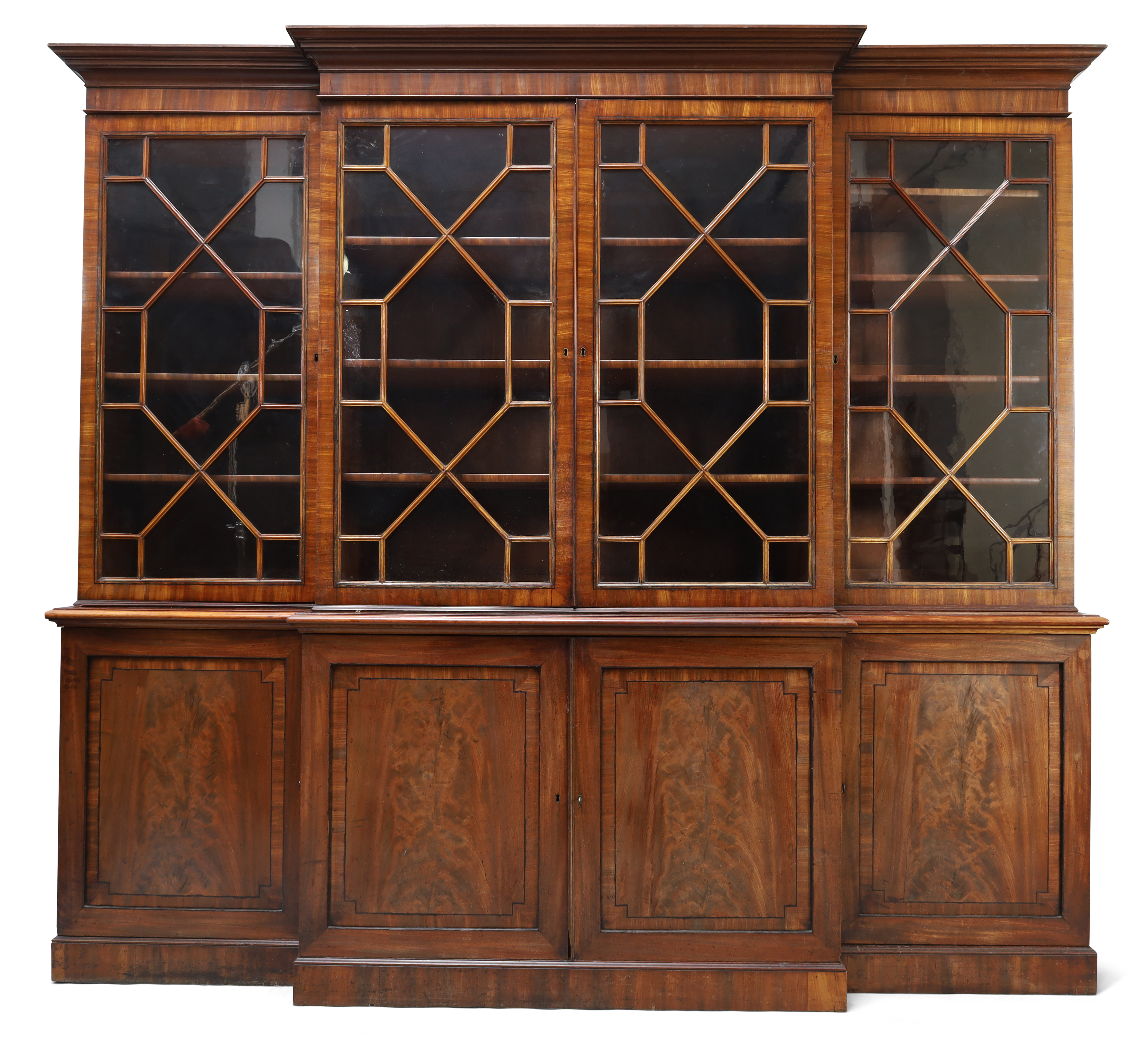 A George III mahogany breakfront library bookcase, c.1780, ebony strung, the moulded stepped corn...