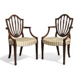 A pair of George III mahogany Hepplewhite style open elbow chairs