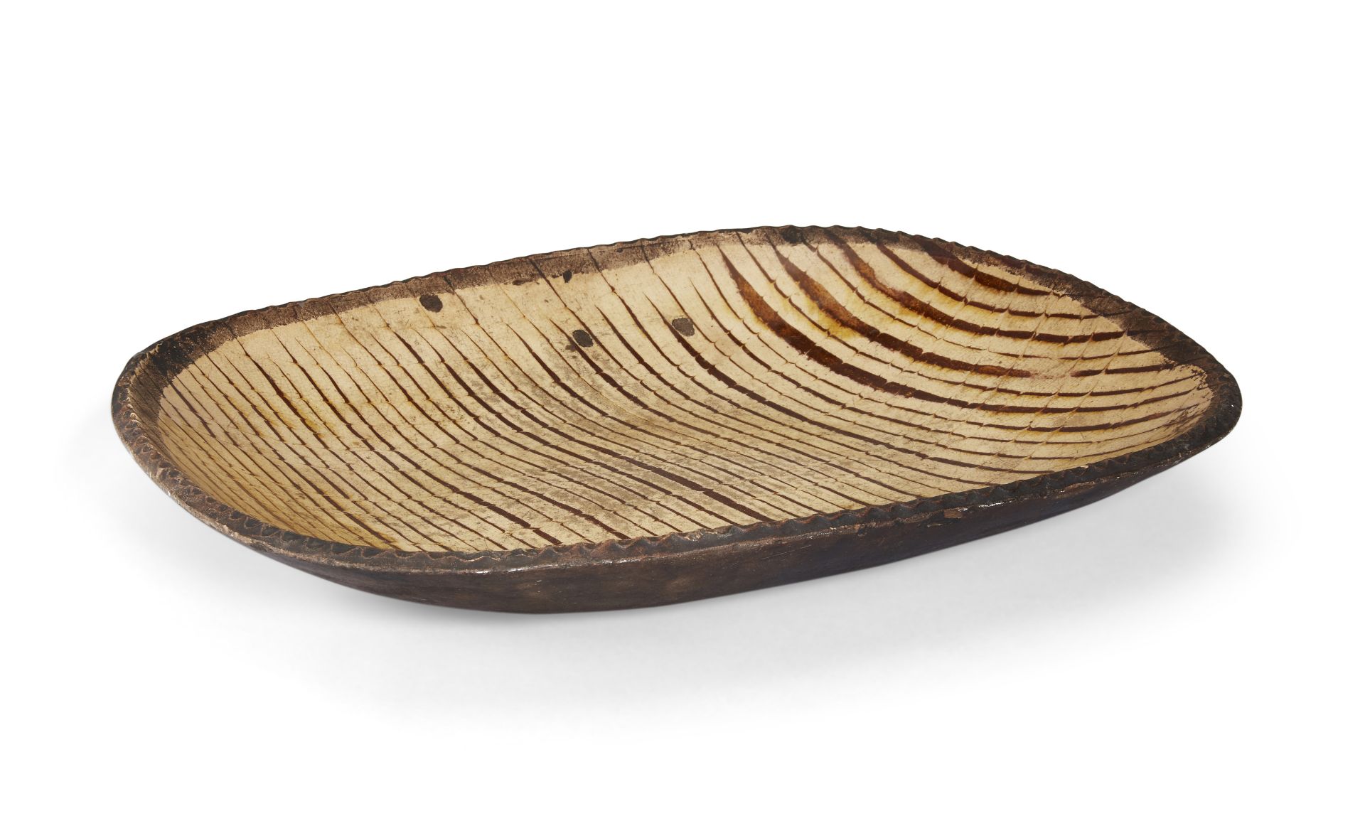 A Staffordshire slipware baking dish, 18th century, of rounded rectangular shallow form with piec...