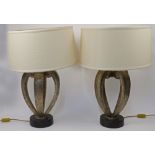 A pair of modern scroll form table lamps, retailed by Fine Art Lamps Miami, each on a black circu...