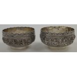 A pair of South Asian bowls, stamped Sterling, each with shaped rims and embossed vignettes of Hi...