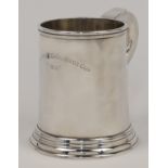 A silver mug, London, 1936, H Phillips, with scroll handle and stepped circular base, engraved AL...