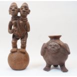 A Nigerian terracotta figure with two heads stood atop a ball, 20th century, approx. 48.5cm high;...
