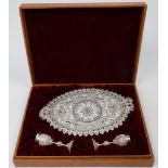 A filigree oval tray and two cups, possibly South Arabian, with pierced foliate decoration, in ca...