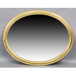 An oval giltwood mirror, first quarter 20th century, with moulded frame, 125cm x 99cm