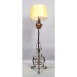 A wrought iron and copper standard lamp, last quarter 19th century, with shade, 184cm high It is...