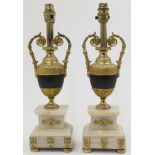 A pair of gilt metal urn shaped table lamps, with bands of repeating stylised floral motifs and t...