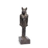 An Egyptian style decorative figure of a striding feline god, set on an integral rectangular base...