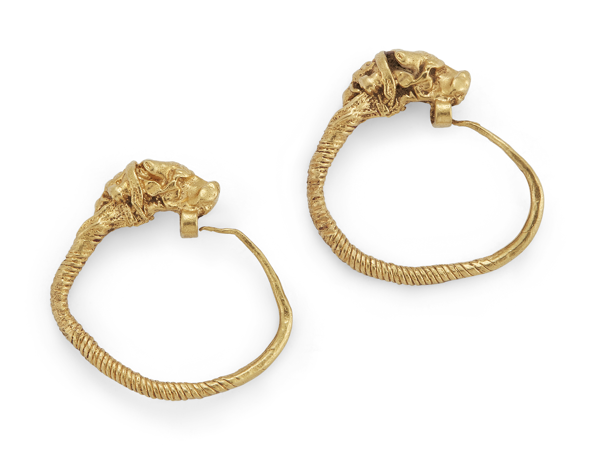 A pair of Hellenistic gold earrings, with bull head terminals, the tapering coiled wire hooking t...