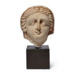 A limestone head of a woman, the himation partially covering her parted and clearly delineated ha...