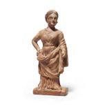 A terracotta standing female figure, wearing a belted chiton, the himation draped over her arm an...