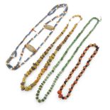 Four necklaces, variously composed of glass, stone, carnelian and faience beads of spherical, dis...