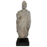 A Gandhara life size standing standing figure of Buddha, 2nd/3rd century, wearing a full length s...