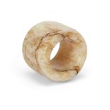 A Chinese 'chicken bone' jade thumb ring Qing dynasty, 17th/18th century Carved from a creamy-w...