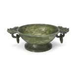 A Chinese spinach jade twin-handled bowl Qing dynasty, 18th century Standing on a splayed foot ...