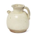 A Chinese white-glazed small ewer Tang dynasty Of bulbous form, with applied strap handle and s...