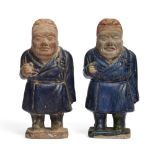 A pair of Chinese pottery Tang-style dwarf figures Ming dynasty Each broad figure modelled stan...