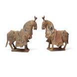 A pair of Chinese painted pottery figures of caparisoned horses Northern Wei dynasty Each model...