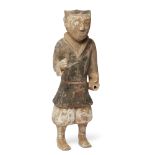 A large Chinese pottery figure of a warrior Han dynasty Modelled standing wearing a tunic with ...