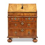 A Queen Anne walnut bureau, first quarter 18th century, the hinged fall front enclosing fitted in...