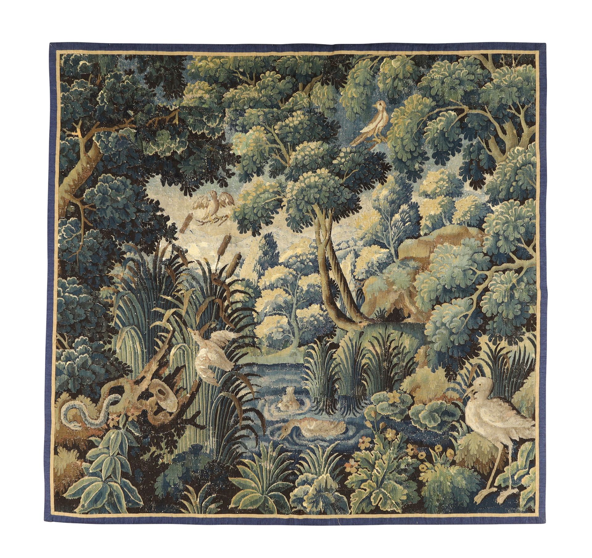 A Flemish verdure tapestry fragment, 17th century, depicting a central lake with bull rushes, sur...